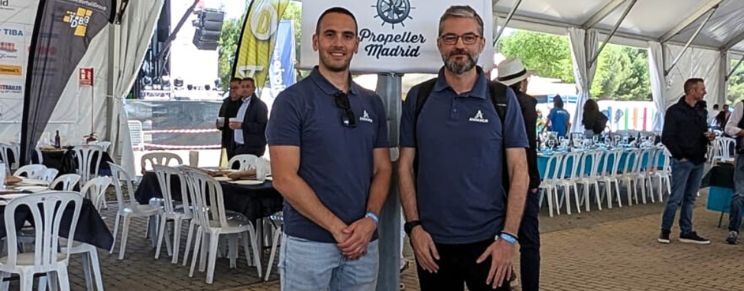 Dos miembros del equipo de Andamur frente a un banner de la Fiesta de la Logística